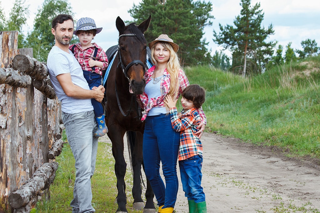 family stands with horse